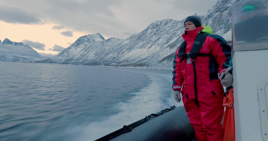 A man stands as a boat moves through the water