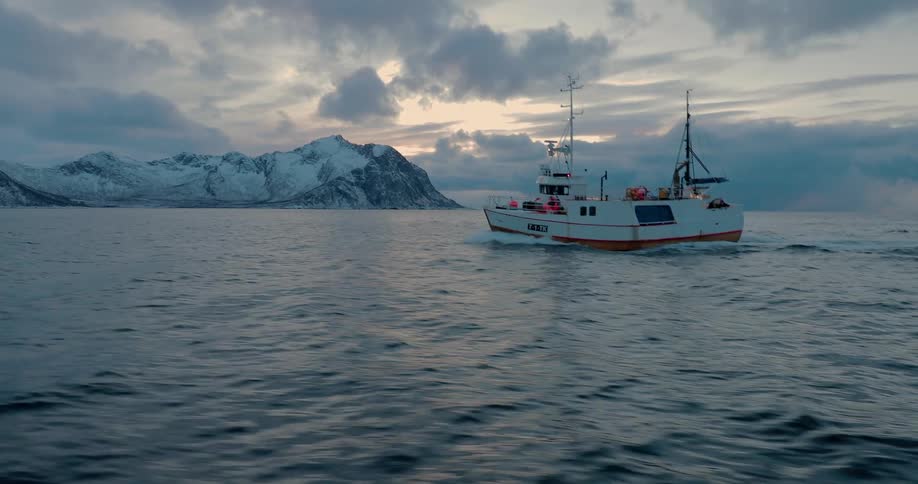 Men sail on cold waters by frozen mountains