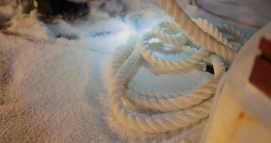 A person secures a boat to the dock using rope
