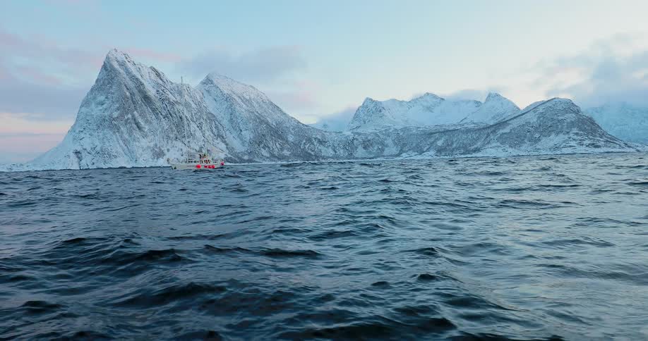 Boat floating on the water near snowy mountains