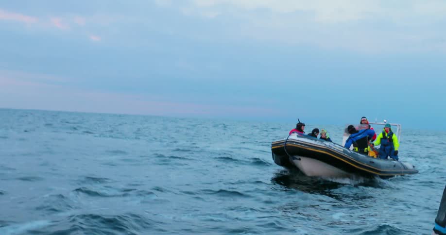 People ride on a small boat in choppy water