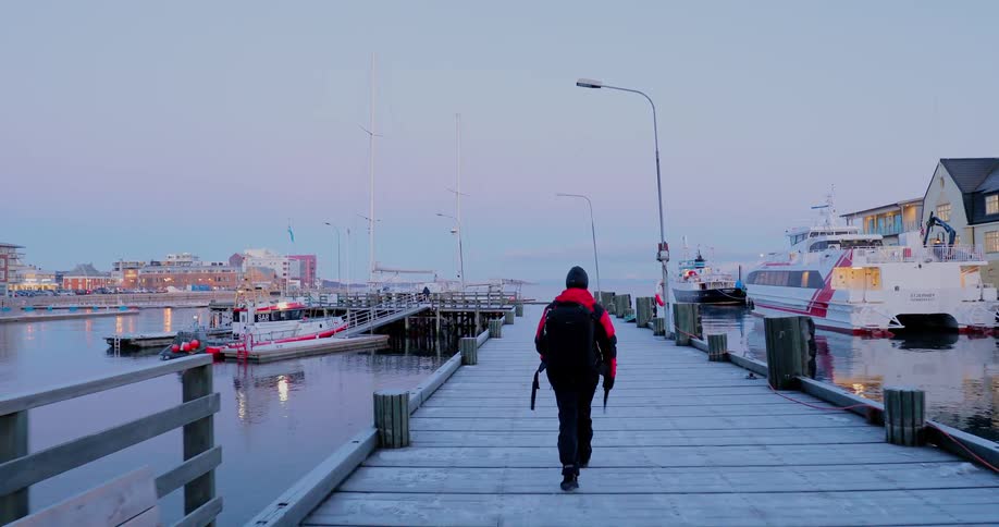 A man walks on an icy pier