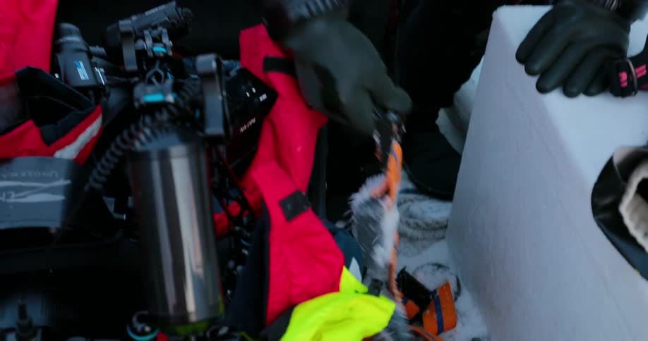 Divers sorting through their equipment on a snowy boat