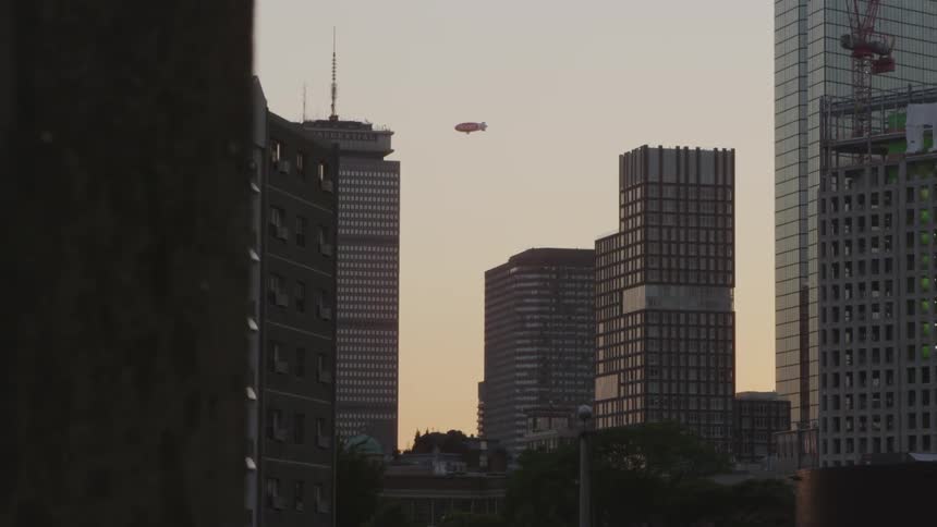 A blimp flies over a city