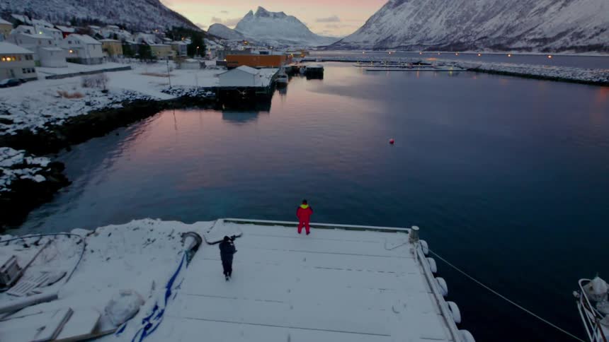 A man is photographed as he walks on a snow covered pier