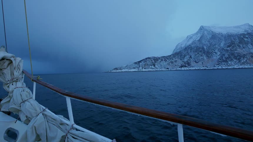 Boat sails on the open water near mountains