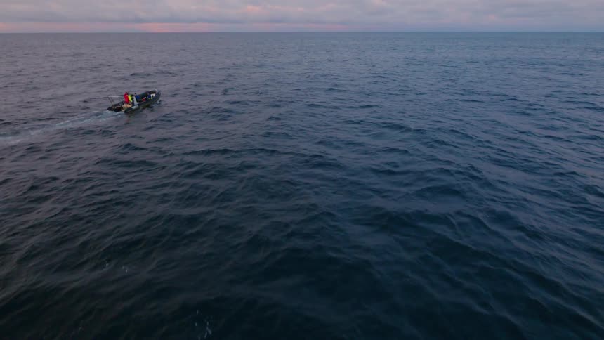 A boat floats on the choppy waters