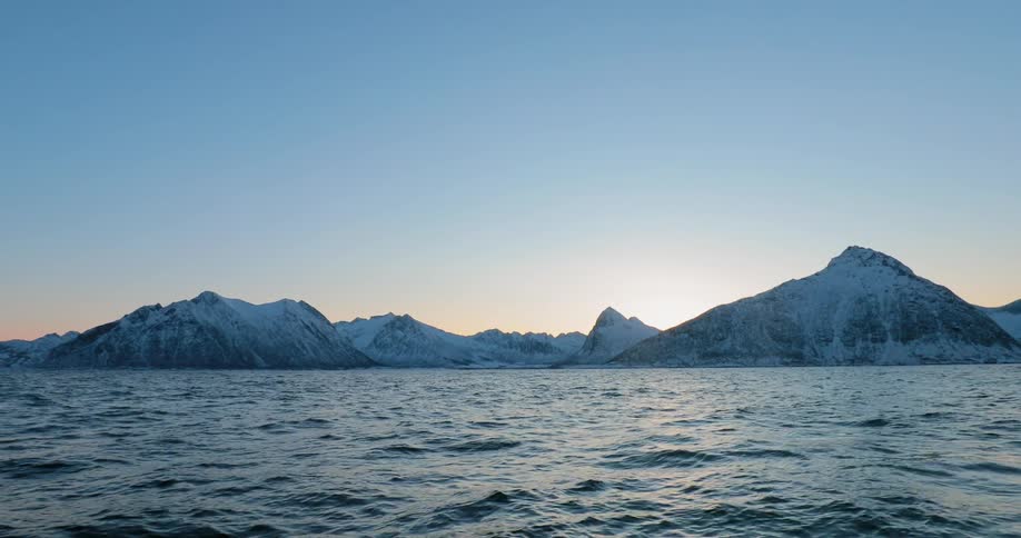 The sun setting behind a frozen island