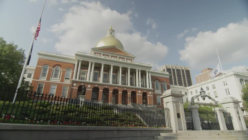 Front of a  large building with flags flying next to it