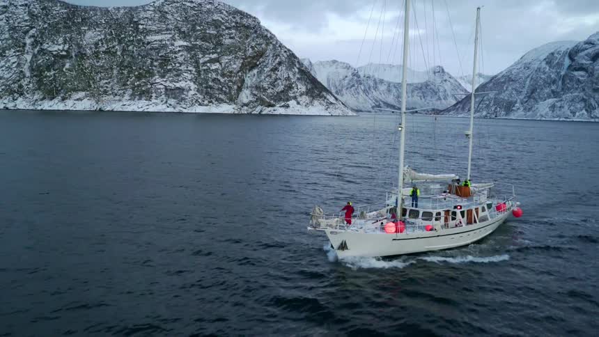 A boat floats off a snowy coast