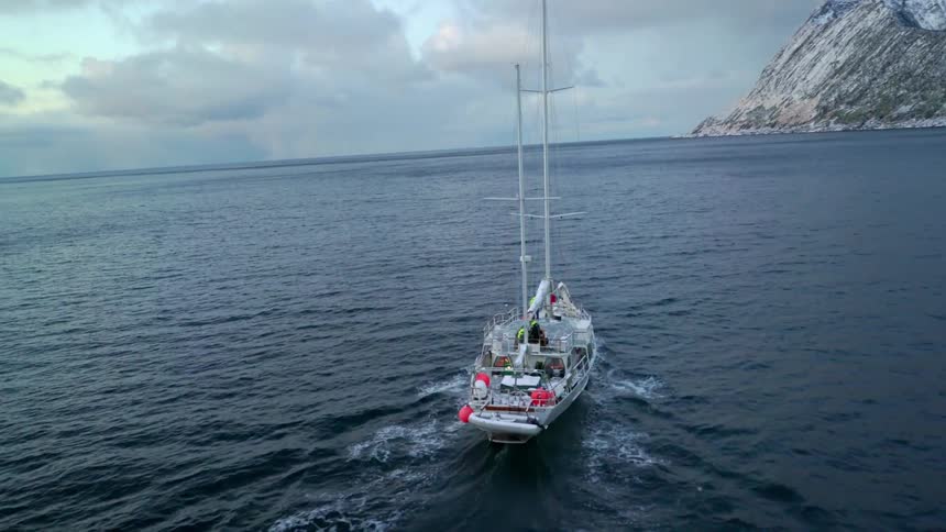 Boat sails on the open water near mountains