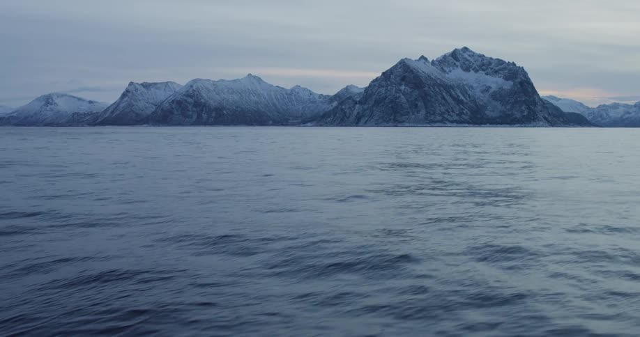 Large body of water surrounded by snowy mountains