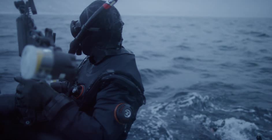A diver gets into the ocean while it snows