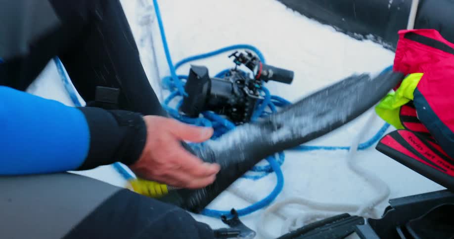 A diver affixes flippers to his feet