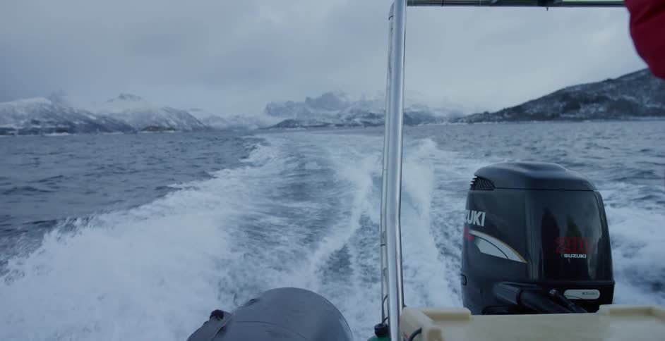 A powerboat travels on the cold waters