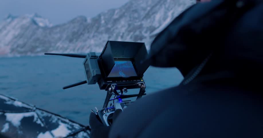 A man films using a remote while riding on a powerboat