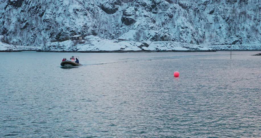People boat just off a snowy coast