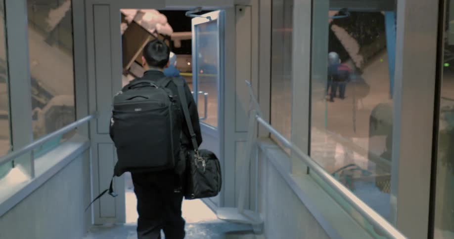People walk through a corridor to the snowy outside