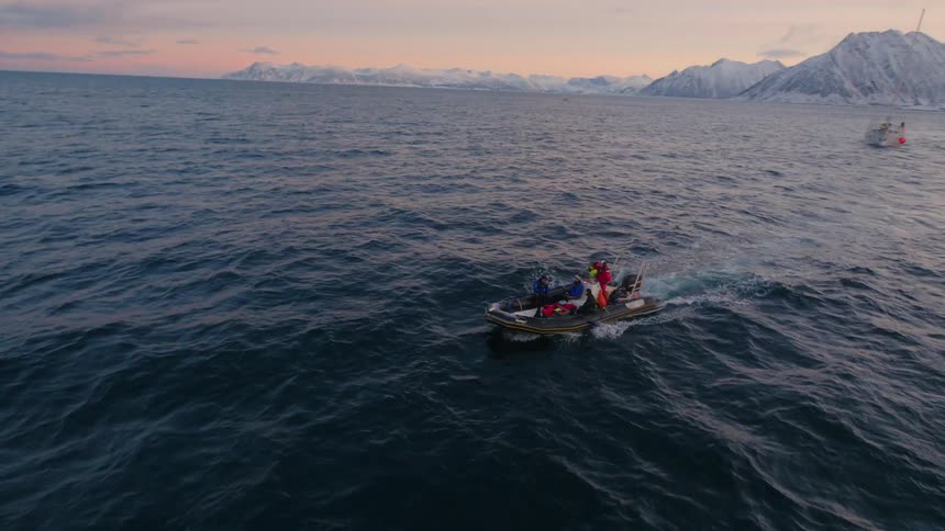 People ride on a small boat in choppy waters