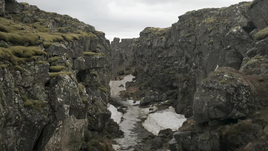 A hiker walks in a snowy canyon