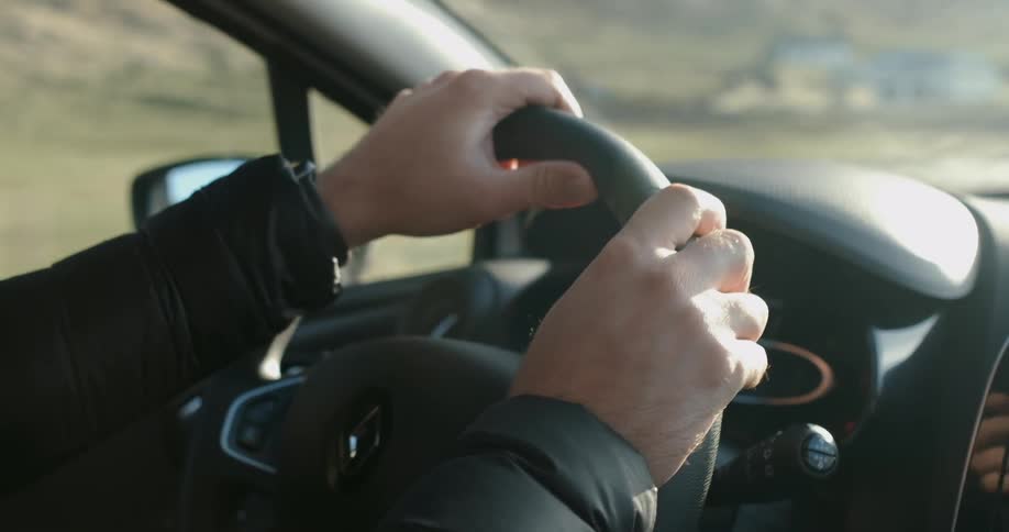 A person is driving a vehicle in a rural area during the day
