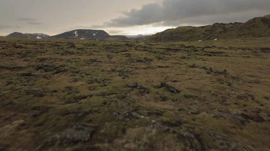 Snow pockets the tundra of a remote setting at dawn