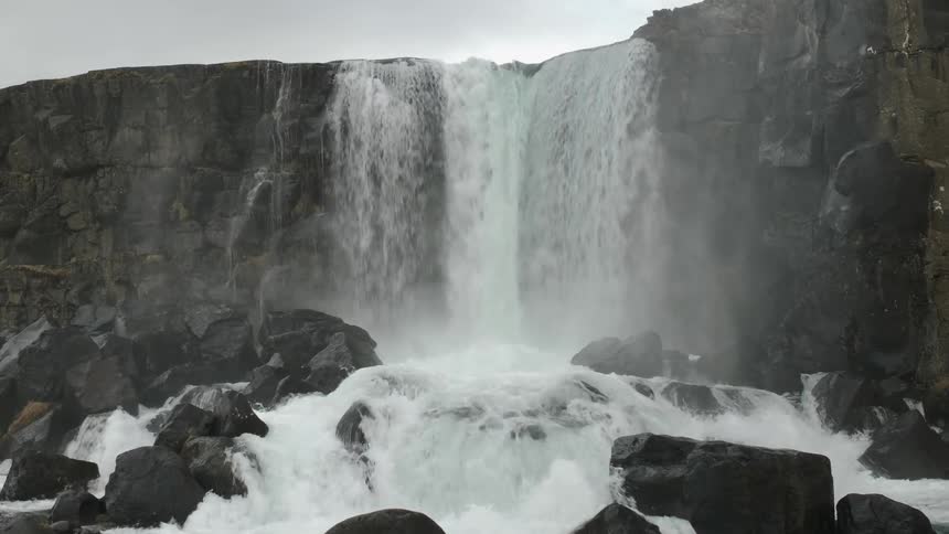 A waterfall flows over a rocky cliff