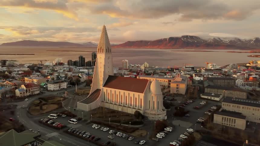 Vehicles travel on a road by a large church building
