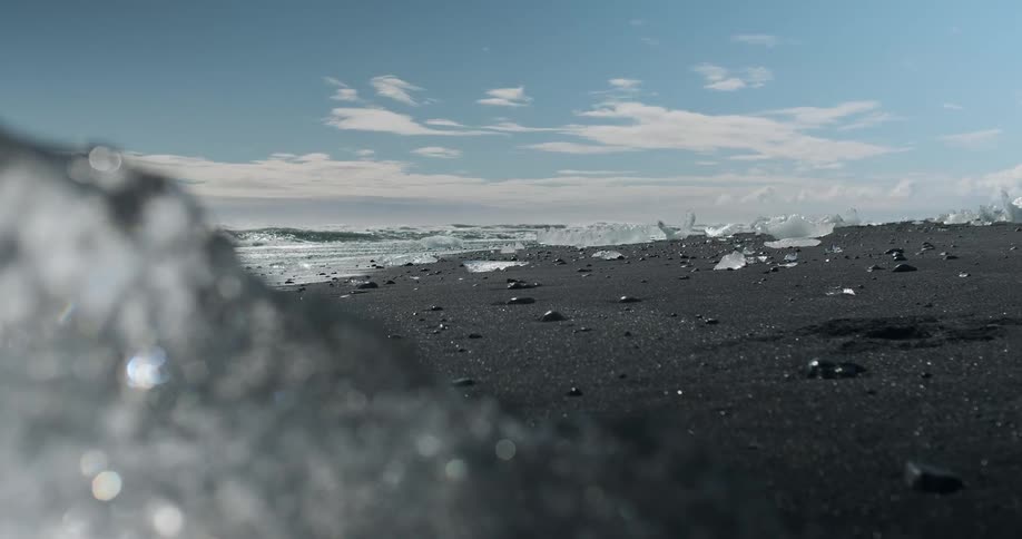 Icebergs are melting on a beach on a sunny day