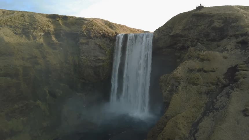 Birds fly by a flowing waterfall