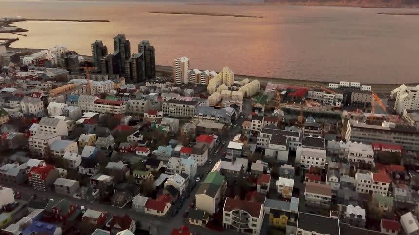 Many different colored buildings in a city near a body of water
