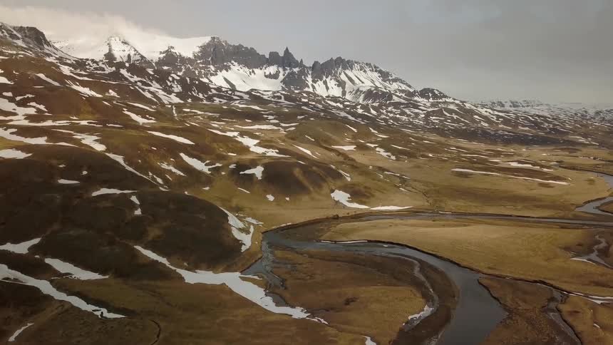 River winding through a valley on a cold and cloudy day