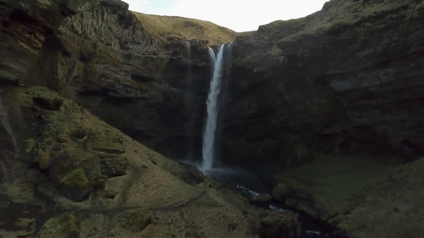 A waterfall flows over a rocky cliff