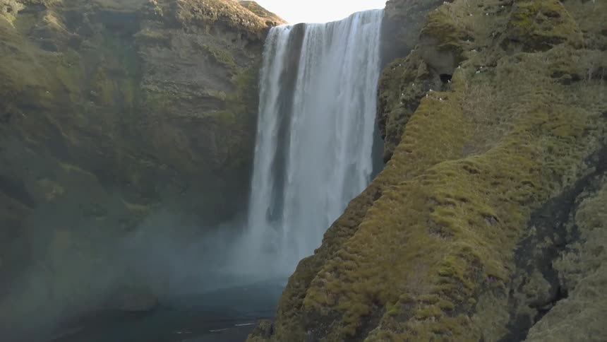 Waterfall splashing off a cliff and misting into a river