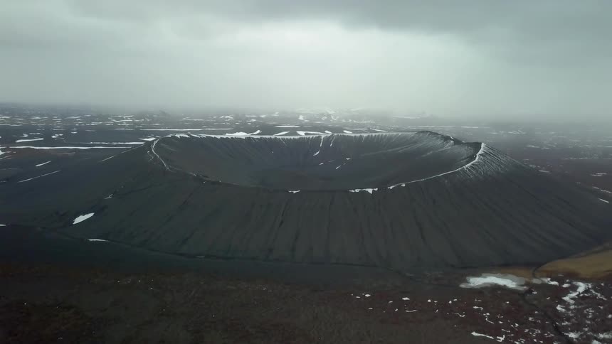 Clouds float over a snowy crater