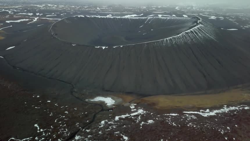 Snow and ice cover the rim of a crater