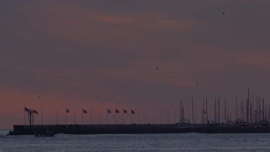 Boat travels to some docks at sunset