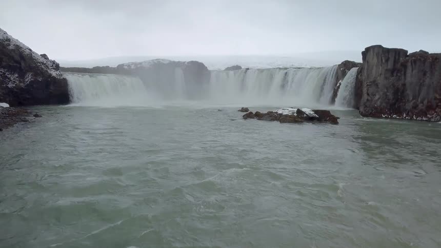 Waters running from a wide waterfall area on a cloudy day