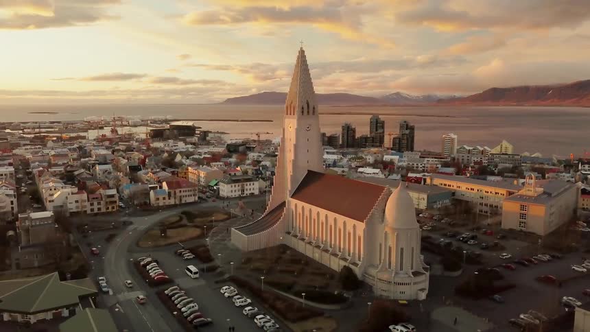Vehicles travel on a road by a large church building