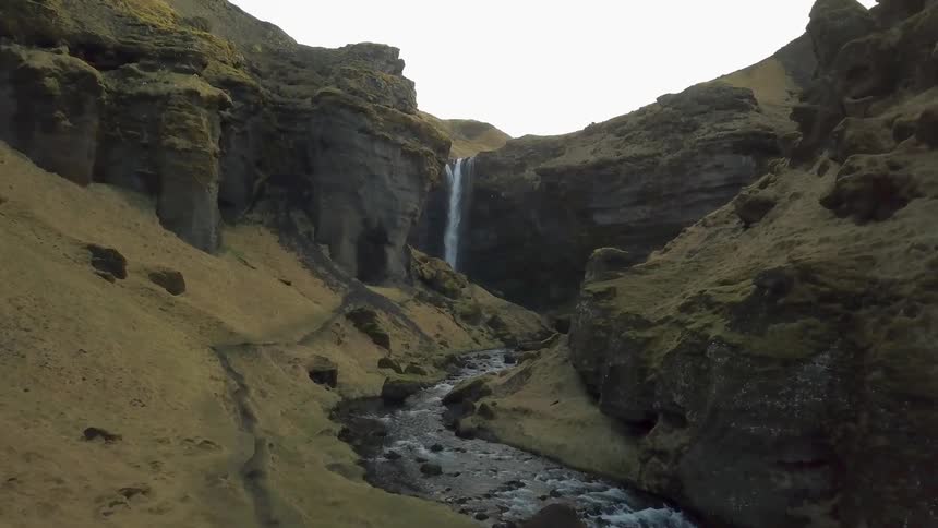 Waterfall splashing off a cliff into a small stream