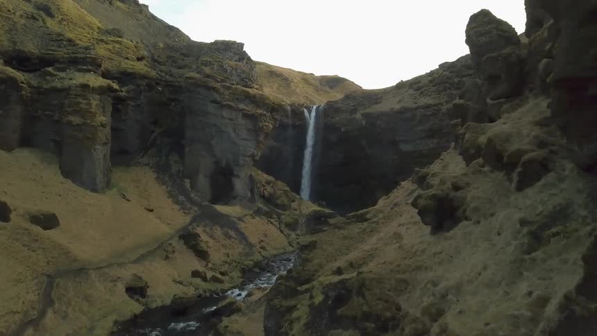 Water falls down a cliff into a stream