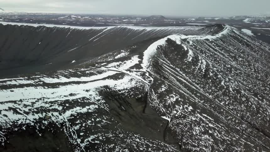 Snow and ice cover the rim of a crater