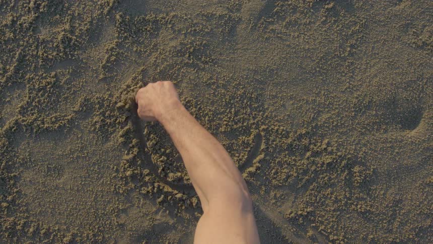 Man traces a circle in the sand