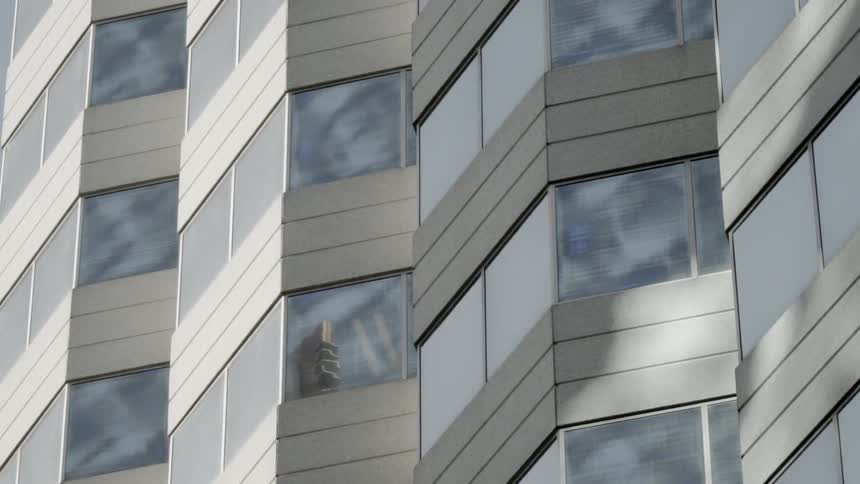 The windows of a city building reflect sunlight