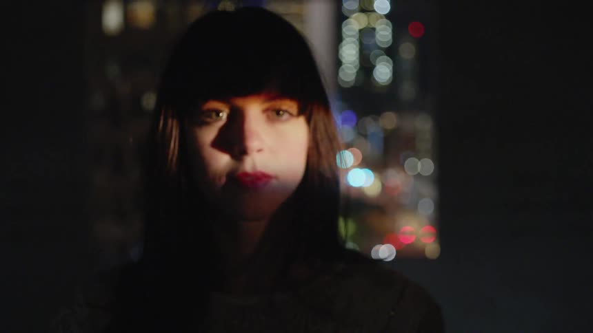 A woman walks towards a stream of light