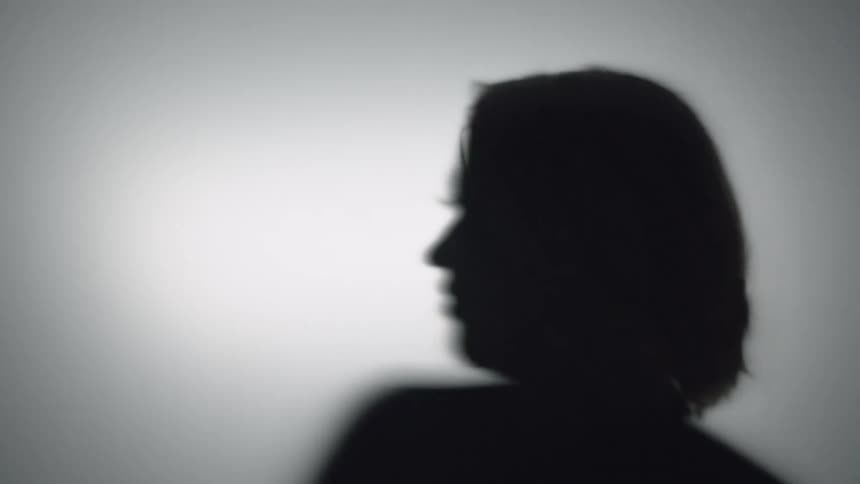 A woman is silhouetted behind a sheet