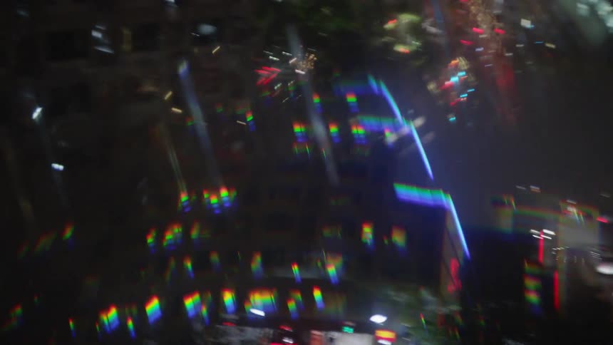 City lights are reflecting through a window at night