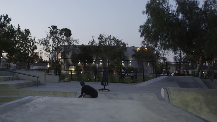 A skateboarder rides down a ramp and grinds on a bench