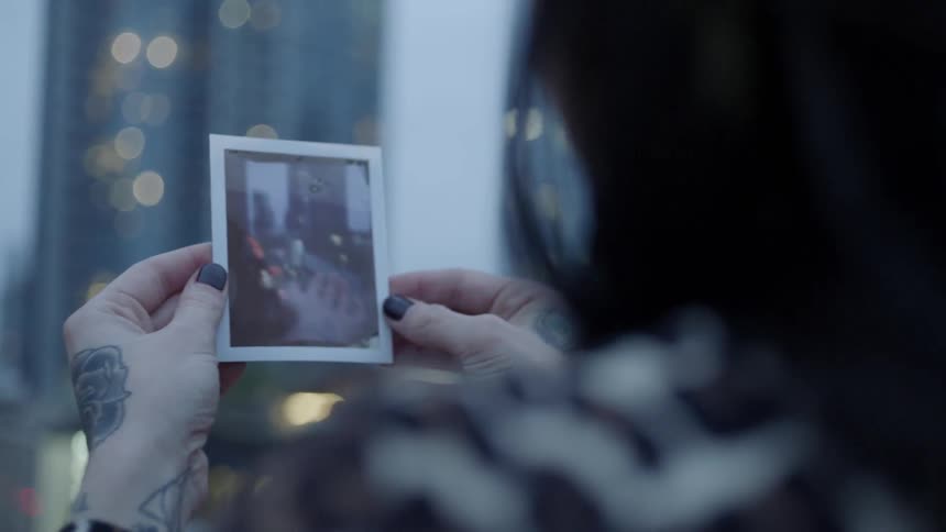 A woman looks at a photograph