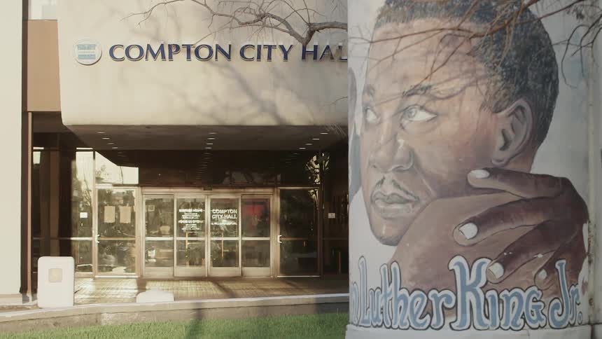 A mural covers a wall next to a city hall